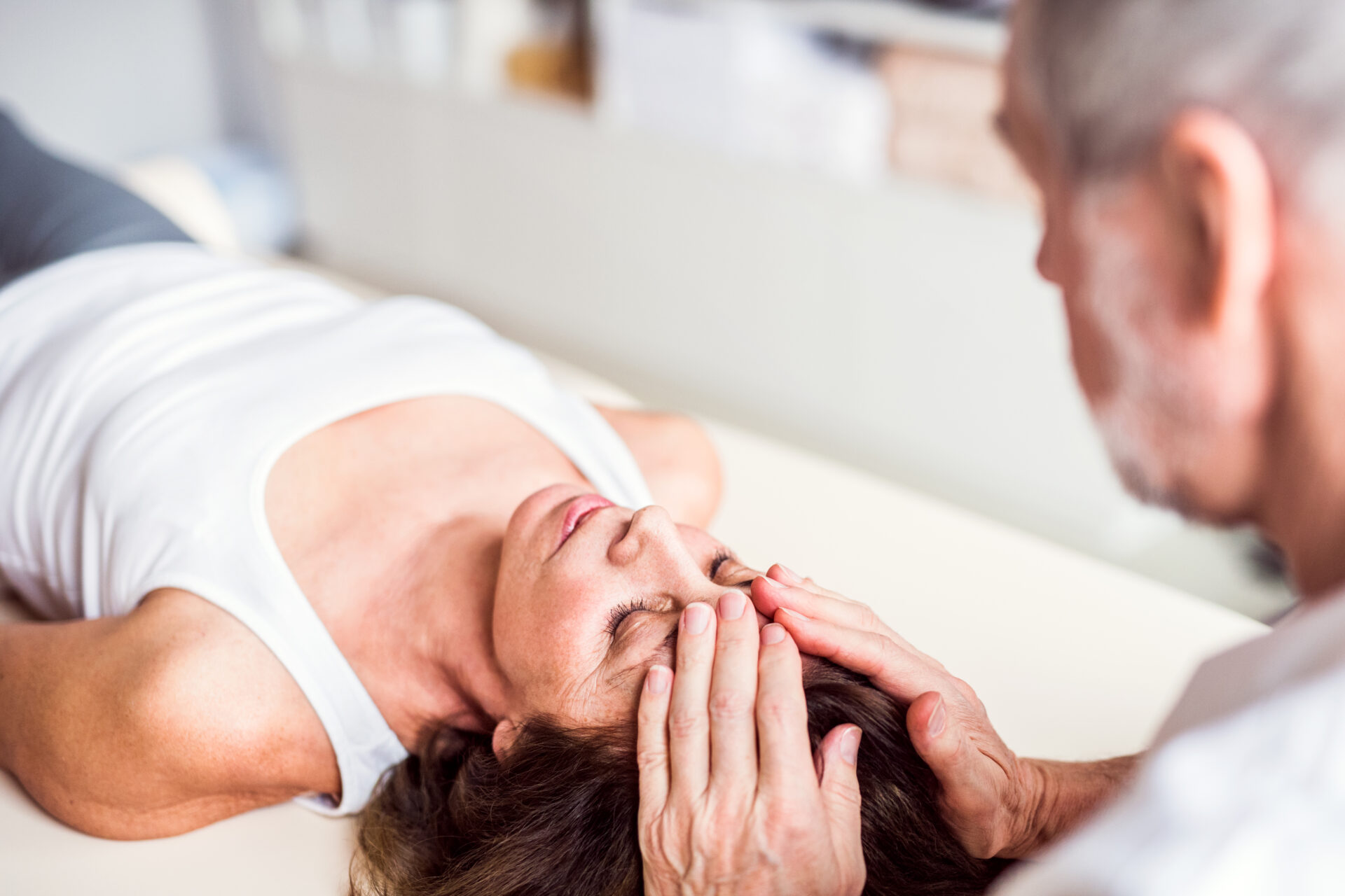 Senior physiotherapist working with a female patient.